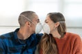 Young couple in quarantine for coronavirus wearing protective mask, he is lying on the couch. Stay at home. Watch tv on quara