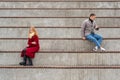 Young couple in a quarrel, a guy and a girl are sitting far from each other in the empty stands Royalty Free Stock Photo