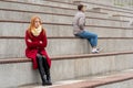 Young couple in a quarrel, a guy and a girl are sitting far from each other in the empty stands Royalty Free Stock Photo