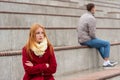 Young couple in a quarrel, a guy and a girl are sitting far from each other in the empty stands Royalty Free Stock Photo