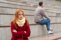 Young couple in a quarrel, a guy and a girl are sitting far from each other in the empty stands Royalty Free Stock Photo