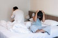 Young couple in quarrel sitting on bed at home. Upset lovers consider break up. Relationship breakdown, family relations, problems