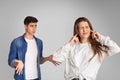 Young couple quarreling, girl covers ears with hands