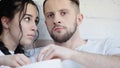 young couple reaching bowl while watching