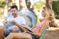 young couple reading in front tent