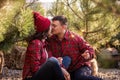 Young couple in red checkered shirts kissing, holding festive sparklers. Christmas tree market Royalty Free Stock Photo