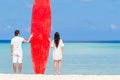 Young couple with red surfboard during tropical vacation Royalty Free Stock Photo