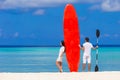 Young couple with red surfboard on white beach Royalty Free Stock Photo