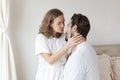 Young couple in a relationship kissing and cuddling. Happy couple hug and kiss on the bed near the window in the morning. Royalty Free Stock Photo