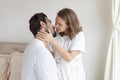 Young couple in a relationship kissing and cuddling. Happy couple hug and kiss on the bed near the window in the morning. Royalty Free Stock Photo