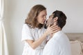 Young couple in a relationship kissing and cuddling. Happy couple hug and kiss on the bed near the window in the morning. Royalty Free Stock Photo