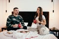 Young couple relaxing in bed drinking coffee and enjoying a moment together Royalty Free Stock Photo