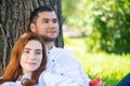 Young couple relaxing with coffee under tree Royalty Free Stock Photo