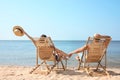 Young couple relaxing in deck chairs on beac Royalty Free Stock Photo