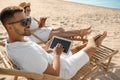 Young couple relaxing in deck chairs on  beach Royalty Free Stock Photo