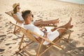 Young couple relaxing in deck  on sandy beach Royalty Free Stock Photo