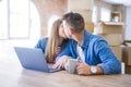 Young couple relaxing drinking a coffee and using the computer laptop around cardboard boxes, very happy moving to a new house Royalty Free Stock Photo