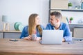 Young couple relaxing drinking a coffee and using the computer laptop around cardboard boxes, very happy moving to a new house Royalty Free Stock Photo