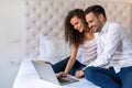 Young couple relaxing at home with laptop. Love, technology, people and fun concept.