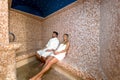 Young couple relaxing inside spa sauna turkish bath - Two lovers enjoying vacation in luxury resort hotel Royalty Free Stock Photo