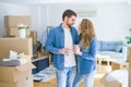 Young couple relaxing from moving to a new house drinking a coffee around cardboard boxes Royalty Free Stock Photo