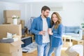 Young couple relaxing from moving to a new house drinking a coffee around cardboard boxes Royalty Free Stock Photo