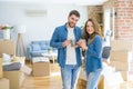 Young couple relaxing from moving to a new house drinking a coffee around cardboard boxes Royalty Free Stock Photo