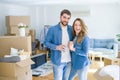 Young couple relaxing from moving to a new house drinking a coffee around cardboard boxes Royalty Free Stock Photo