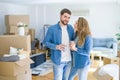 Young couple relaxing from moving to a new house drinking a coffee around cardboard boxes Royalty Free Stock Photo