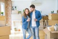 Young couple relaxing from moving to a new house drinking a coffee around cardboard boxes Royalty Free Stock Photo