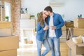Young couple relaxing from moving to a new house drinking a coffee around cardboard boxes Royalty Free Stock Photo