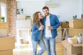 Young couple relaxing from moving to a new house drinking a coffee around cardboard boxes Royalty Free Stock Photo