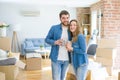 Young couple relaxing from moving to a new house drinking a coffee around cardboard boxes Royalty Free Stock Photo