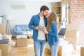 Young couple relaxing from moving to a new house drinking a coffee around cardboard boxes Royalty Free Stock Photo