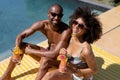 Young couple relaxing near swimming pool on a sunny day Royalty Free Stock Photo