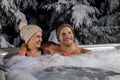 Young couple relaxing in outdoor hot tub in winter Royalty Free Stock Photo