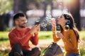 Couple relaxing in the park with bubble blower Royalty Free Stock Photo
