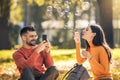 Couple relaxing in the park with bubble blower Royalty Free Stock Photo