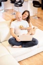 A young couple relaxing on the sofa with a laptop. Social networking. Concept of love, happiness, people and fun. Family concept, Royalty Free Stock Photo