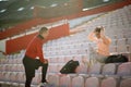 A young couple is relaxing and talking on the grandstand after a good training at the stadium. Sport, athletics, athletes Royalty Free Stock Photo