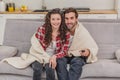 Young couple relaxing in their apartment, lying on the couch, watching a movie. Royalty Free Stock Photo