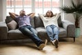 Young couple relaxing together on sofa enjoying nap breathing
