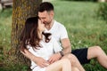 Young couple relaxing under tree in park on sunny day. Happy couple in love spend time outdoors together. Handsome man and pretty Royalty Free Stock Photo