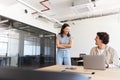 Young couple renting work space for start up business flirting by desk in open plan office Royalty Free Stock Photo