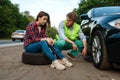 Young couple repair flat tyre, car breakdown Royalty Free Stock Photo