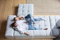 Young couple resting at home on couch, top view, copy space. Domestic life Royalty Free Stock Photo