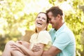 Young Couple Resting On Tree In Park Royalty Free Stock Photo