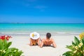 Young couple resting on tropical beach on summer sunny day on background of clear blue sky and turquoise sea. Royalty Free Stock Photo