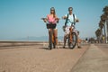 Young couple riding bicycles down the Venice beach
