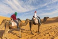 Young couple riding a camel in the middle of a desert in marocco Royalty Free Stock Photo